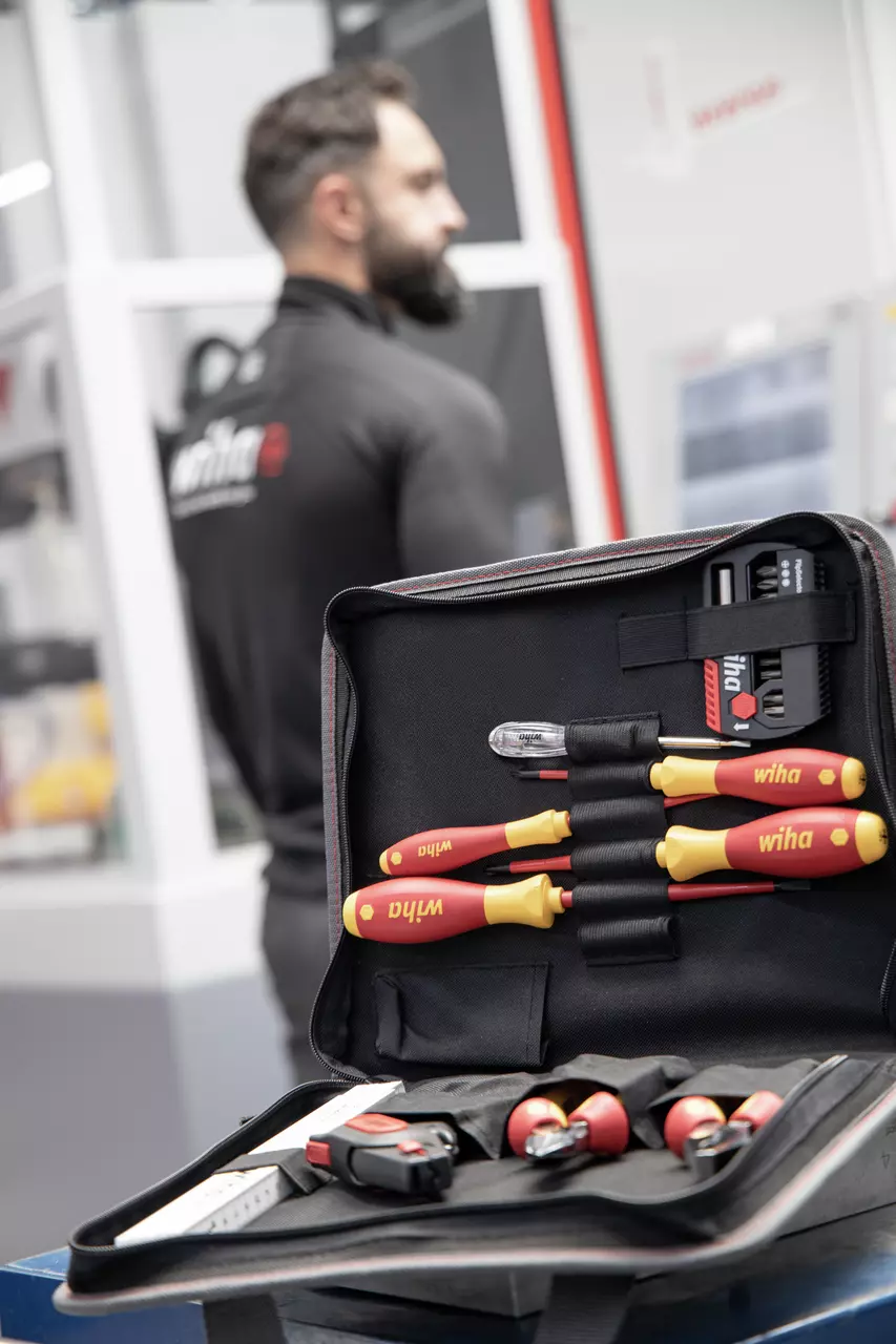 Tool set in an open case with red and yellow handles, person in background.