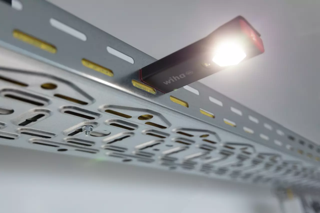 Magnetische Handlampe an einer Metalloberfläche, die helles Licht ausstrahlt.