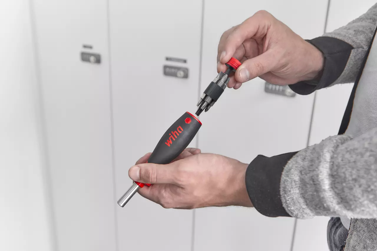 Person holding a screwdriver with a detachable bit holder