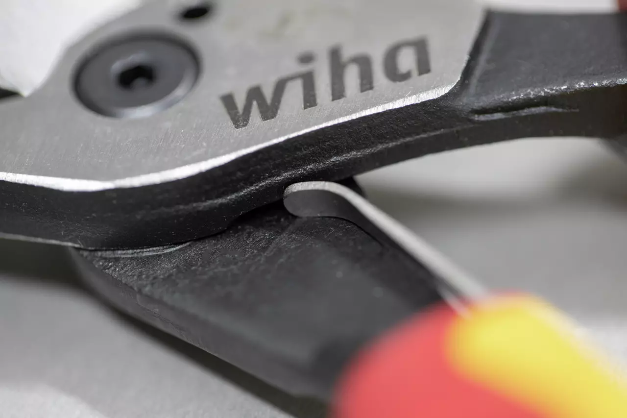 Close-up van een tang met het "wiha" logo op het metalen oppervlak.