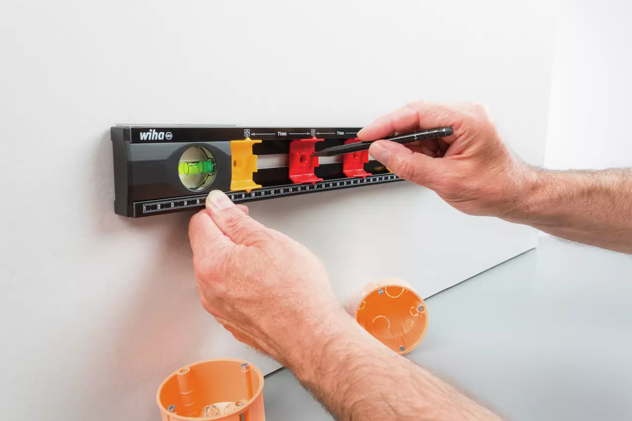 Person using a black level with colored markers on a wall
