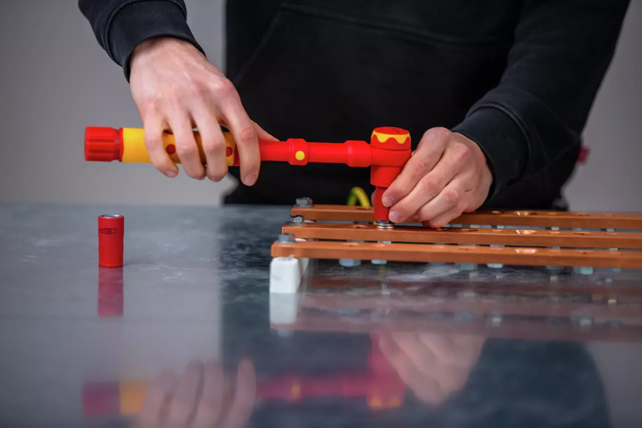 Person using red torque wrench on metal plate