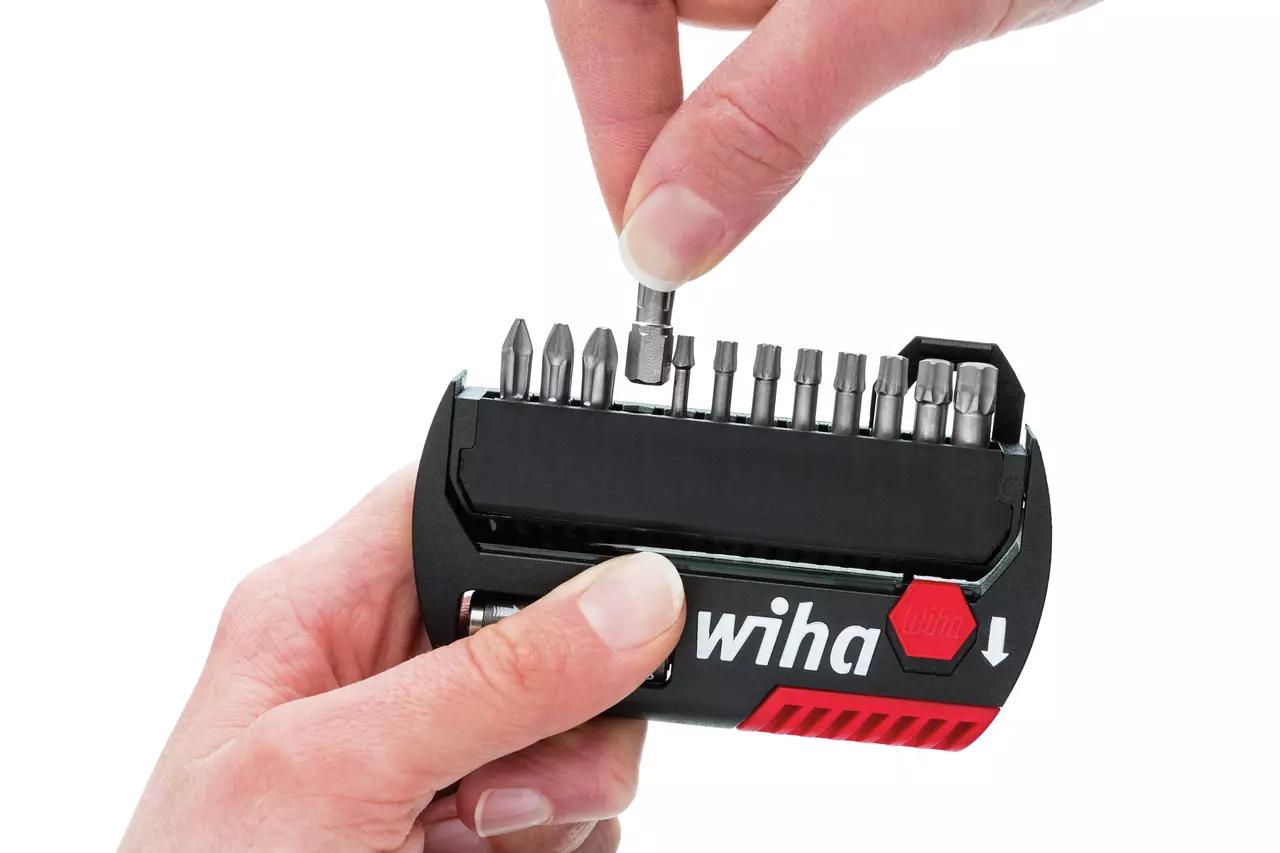Hand selecting a screwdriver bit from a compact bit holder