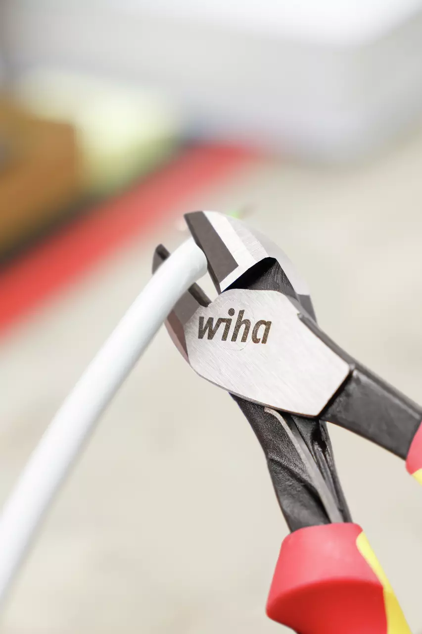 Industrial side cutter cutting a white cable