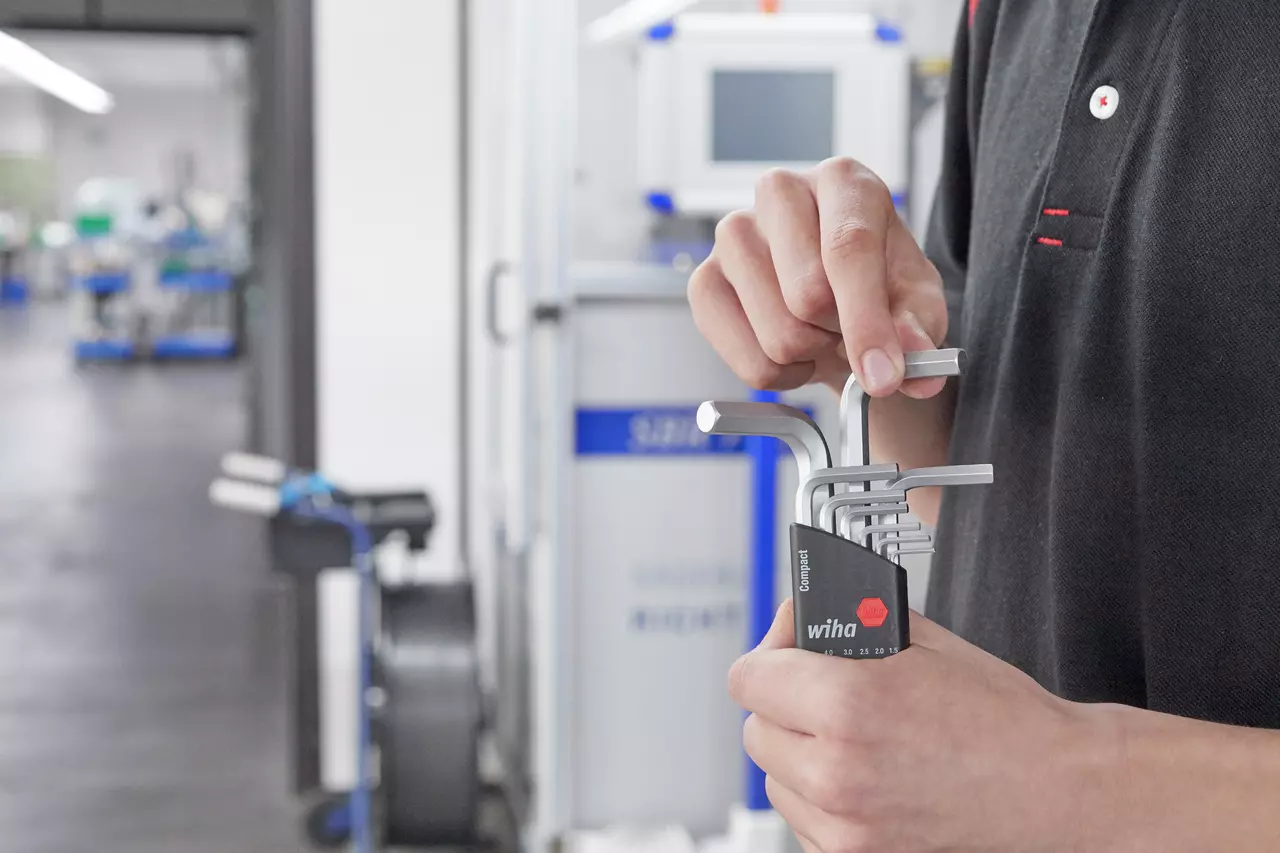 A person holds a set of hex keys in a workshop.