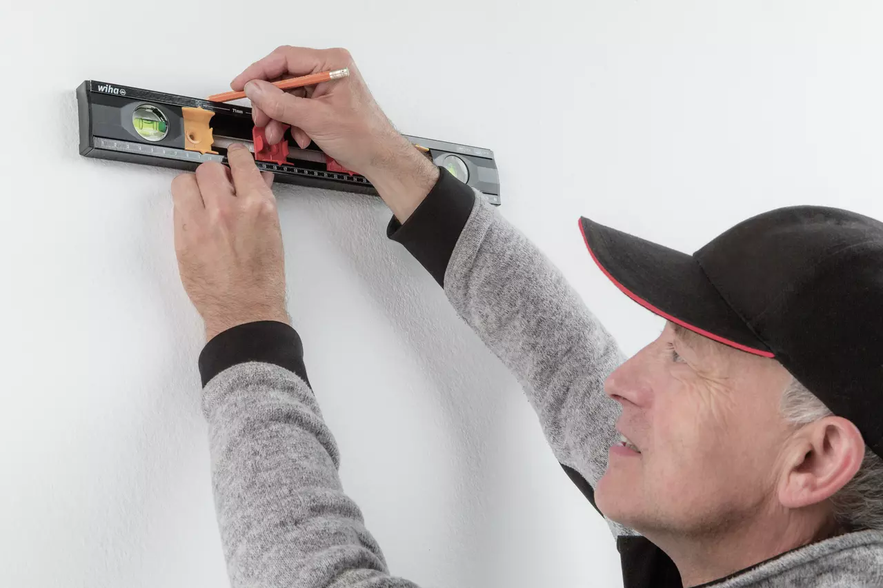 Person using a level on a wall