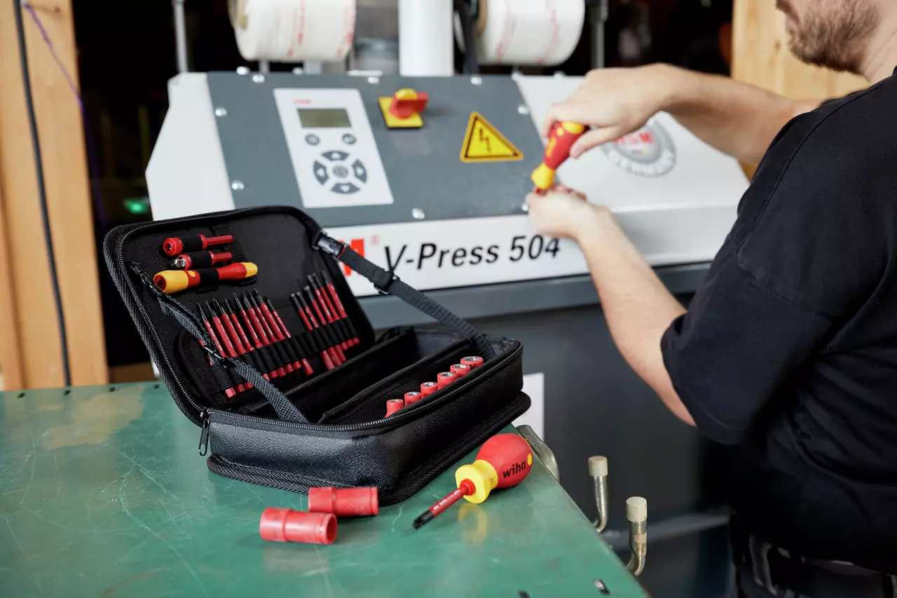 A person using a screwdriver on a machine
