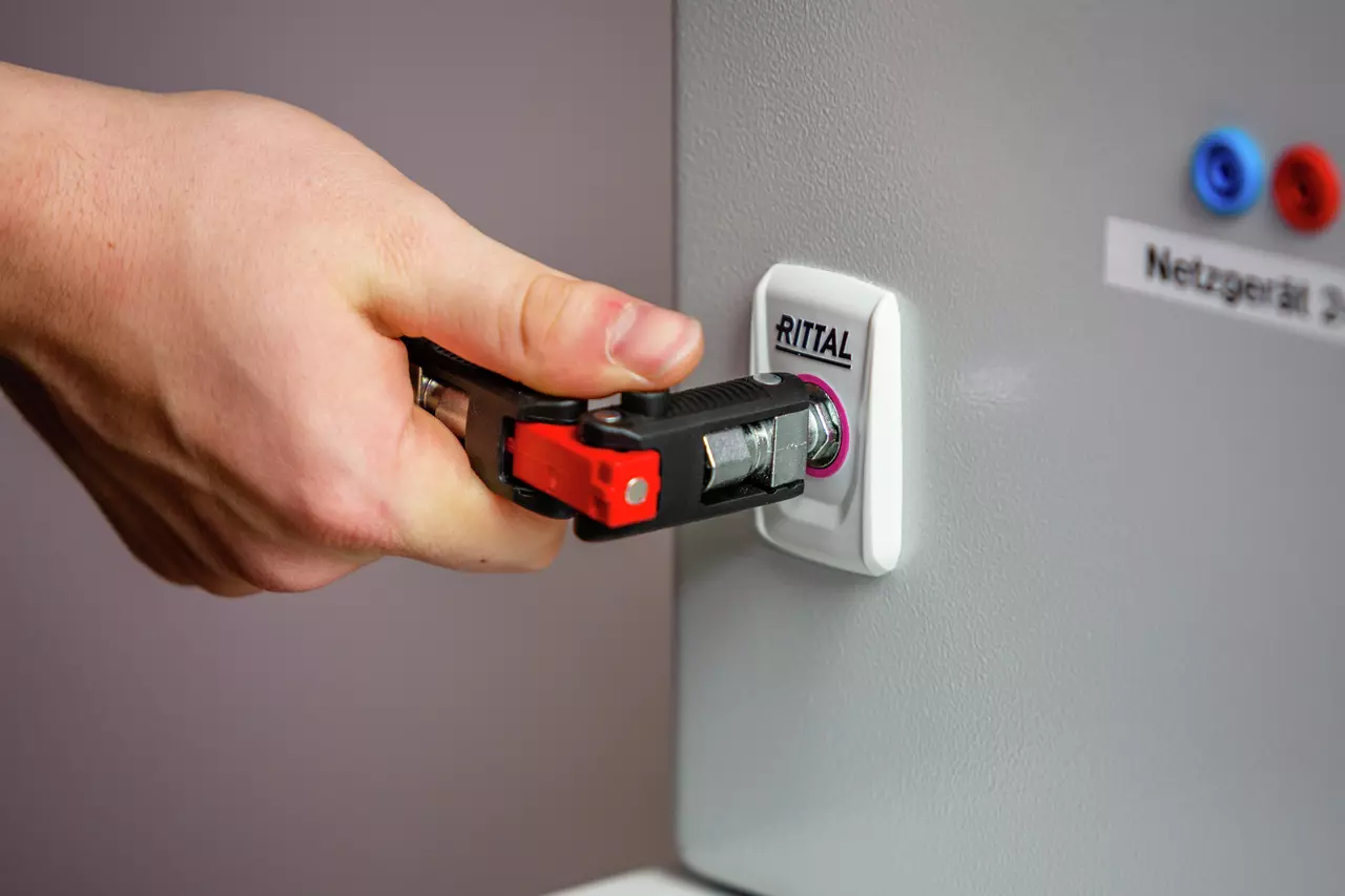 A hand using a universal key on a panel lock