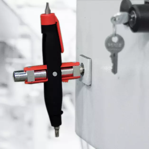 Cabinet key tool with red and black handle inserted in lock