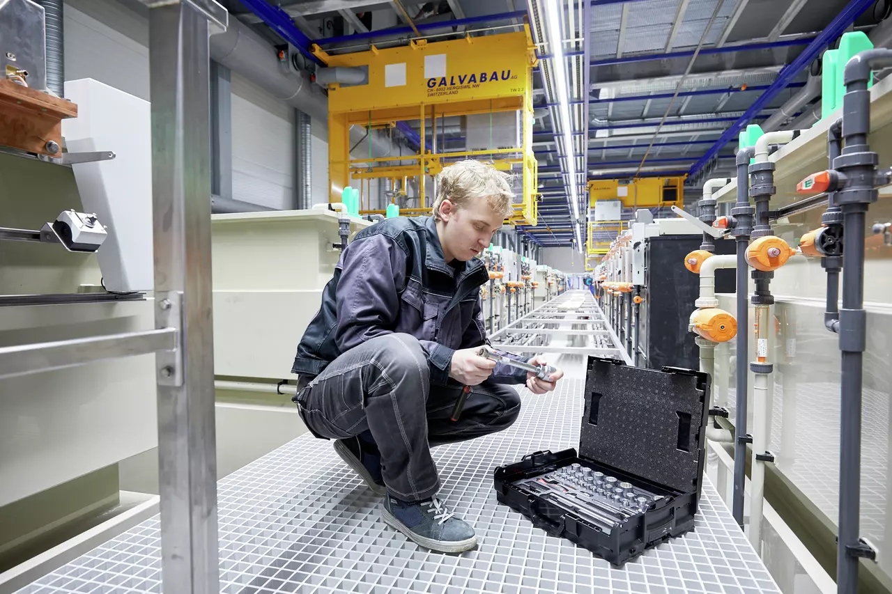 A person working with a socket set in an industrial setting.