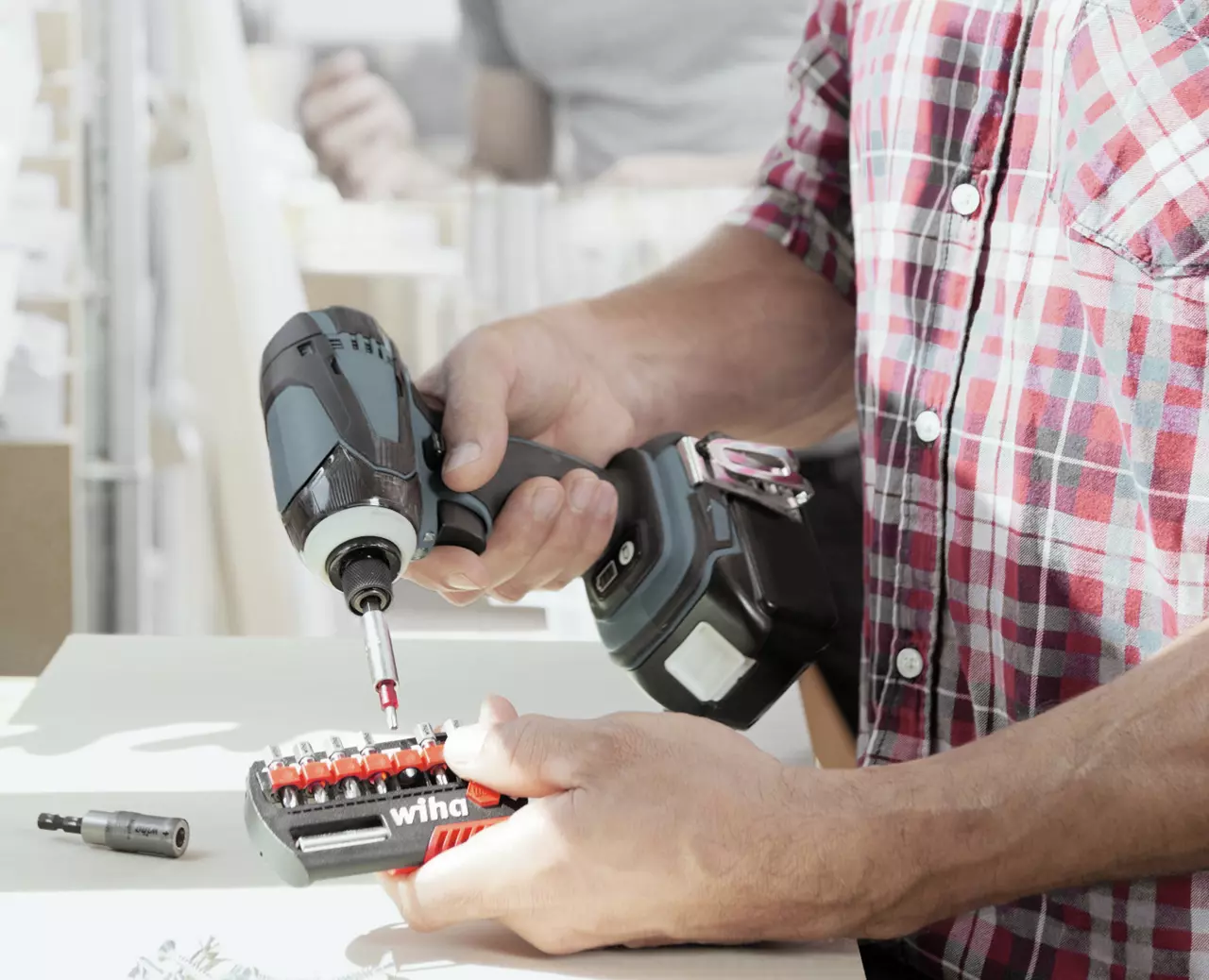 Person using a cordless drill with a set of bits