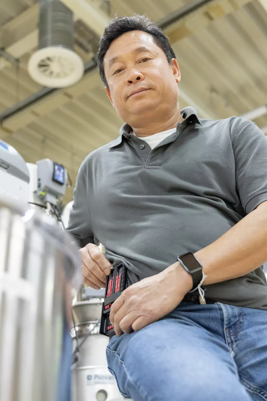 A person in a gray shirt holding a tool set.