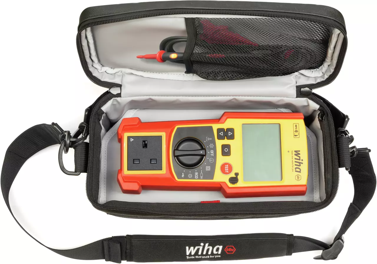 Een digitale multimeter in een zwart draagetui met riem, met sondes in een netzak.