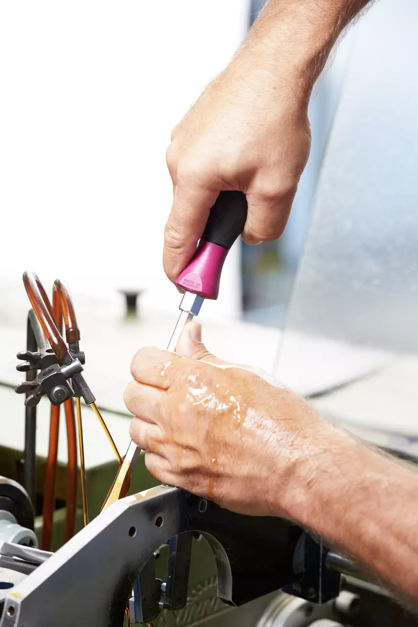 Person using screwdriver on a machine