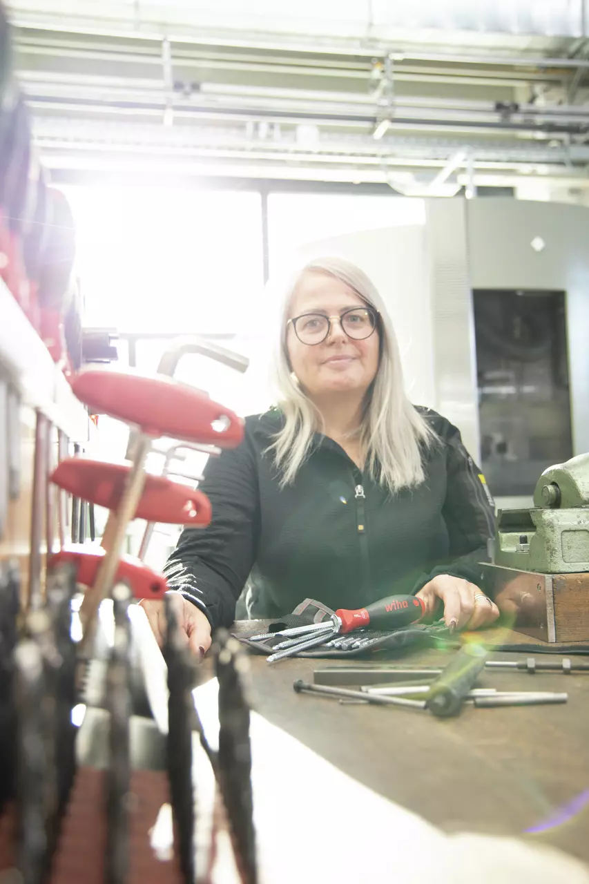 Woman in workshop with screwdrivers and tools on a table.