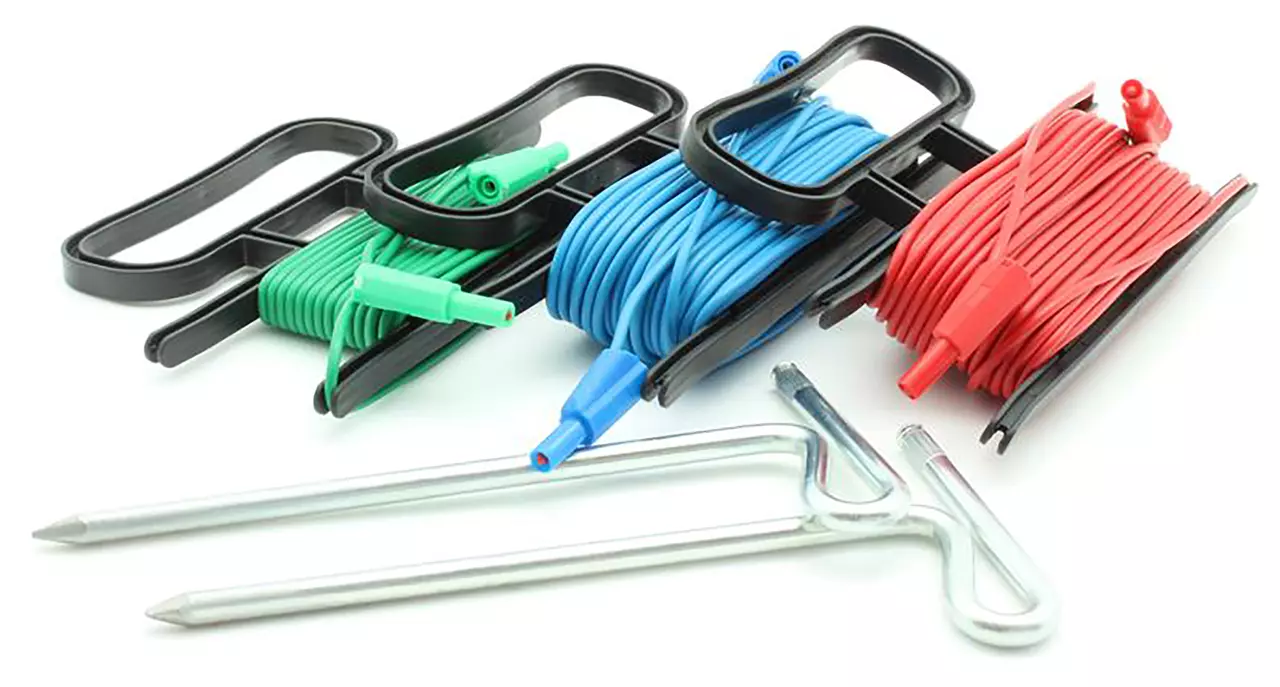Set of green, blue, and red cables on black reels with metal stakes