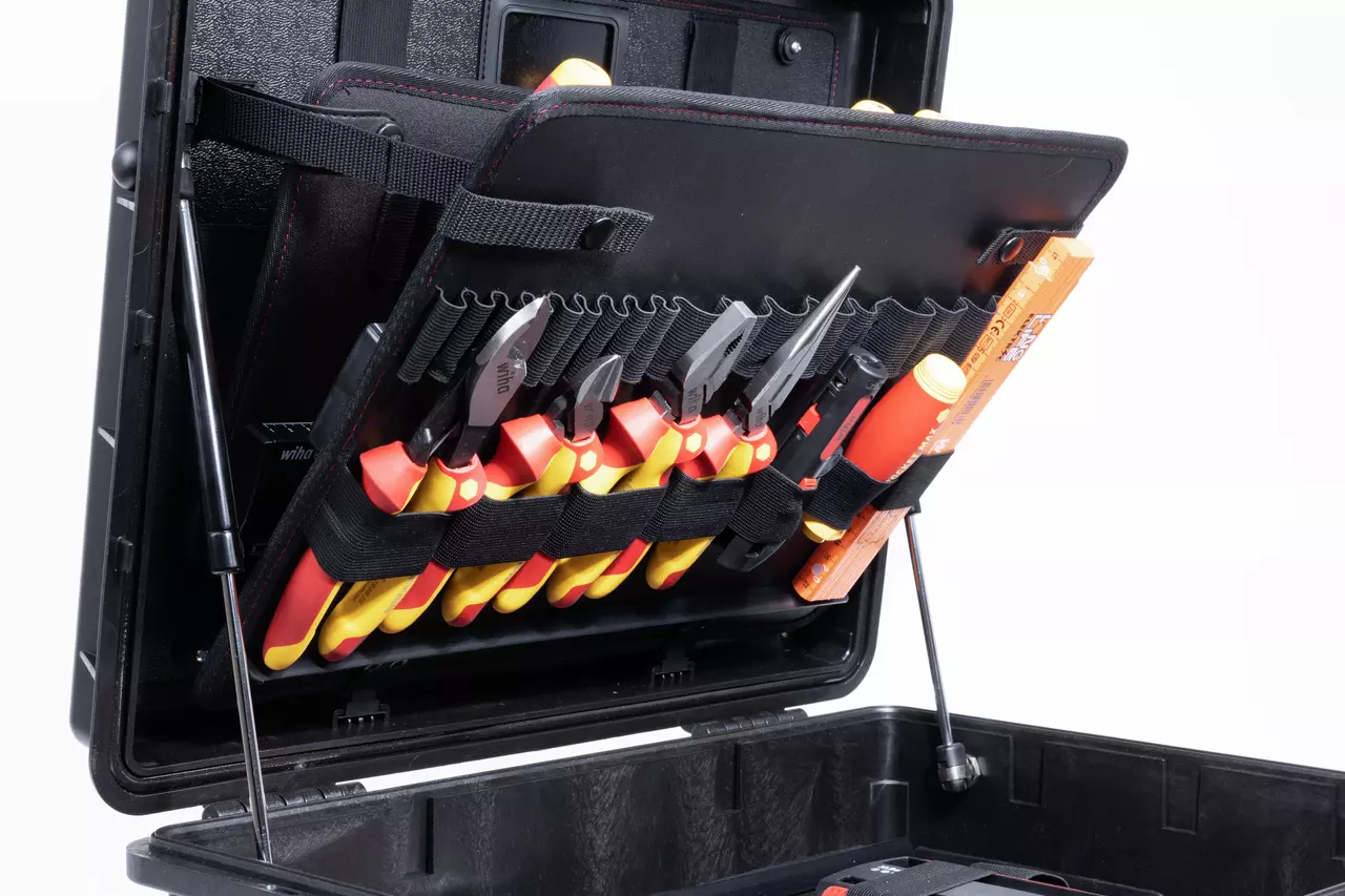 Open tool case with assorted insulated tools in elastic loops, including pliers and screwdrivers.