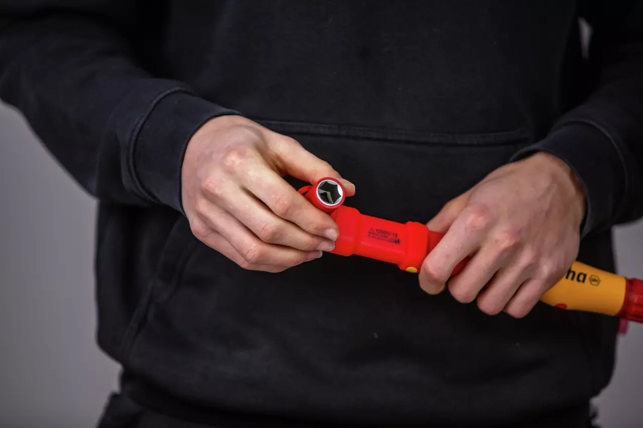 Person holding a red torque wrench