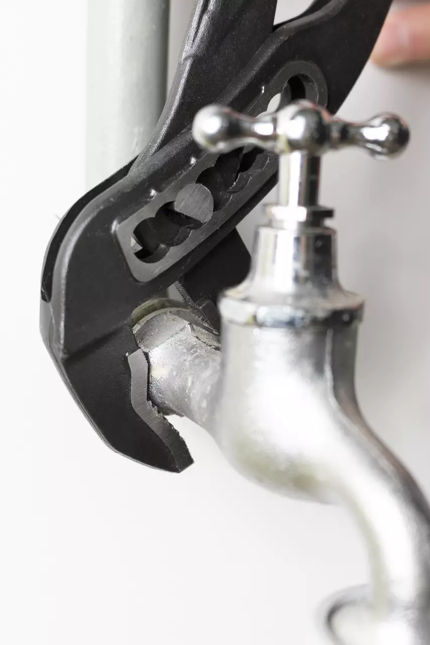 Water pump pliers gripping a metal pipe fitting