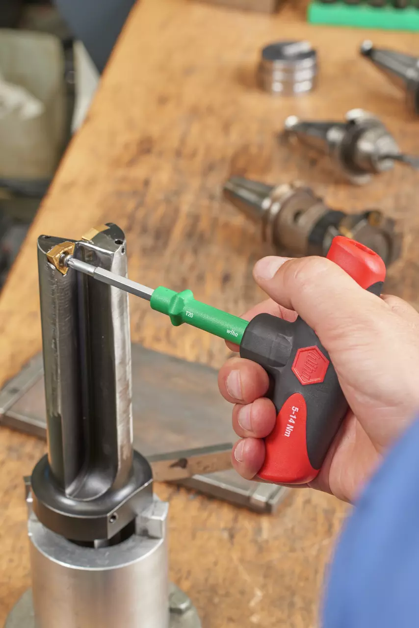 Person using torque screwdriver on metal part