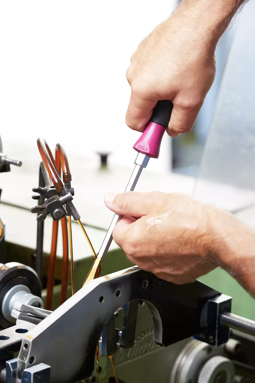 Person using a MicroFinish screwdriver on machinery
