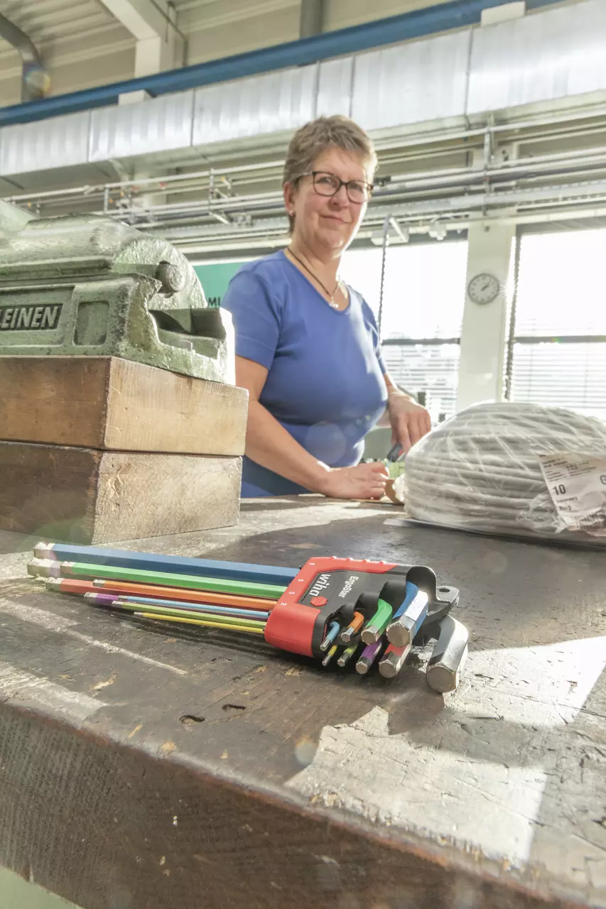 Set of colorful L-keys on a table, person working in background