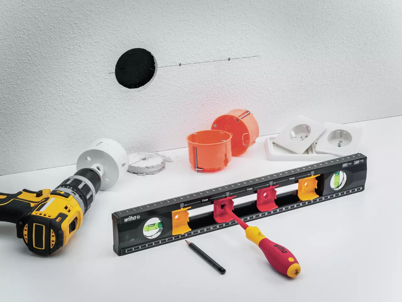 Electrician's level, drill, and socket parts on a white surface