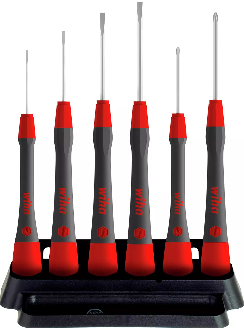 Set of fine screwdrivers with red and black handles in a black stand.