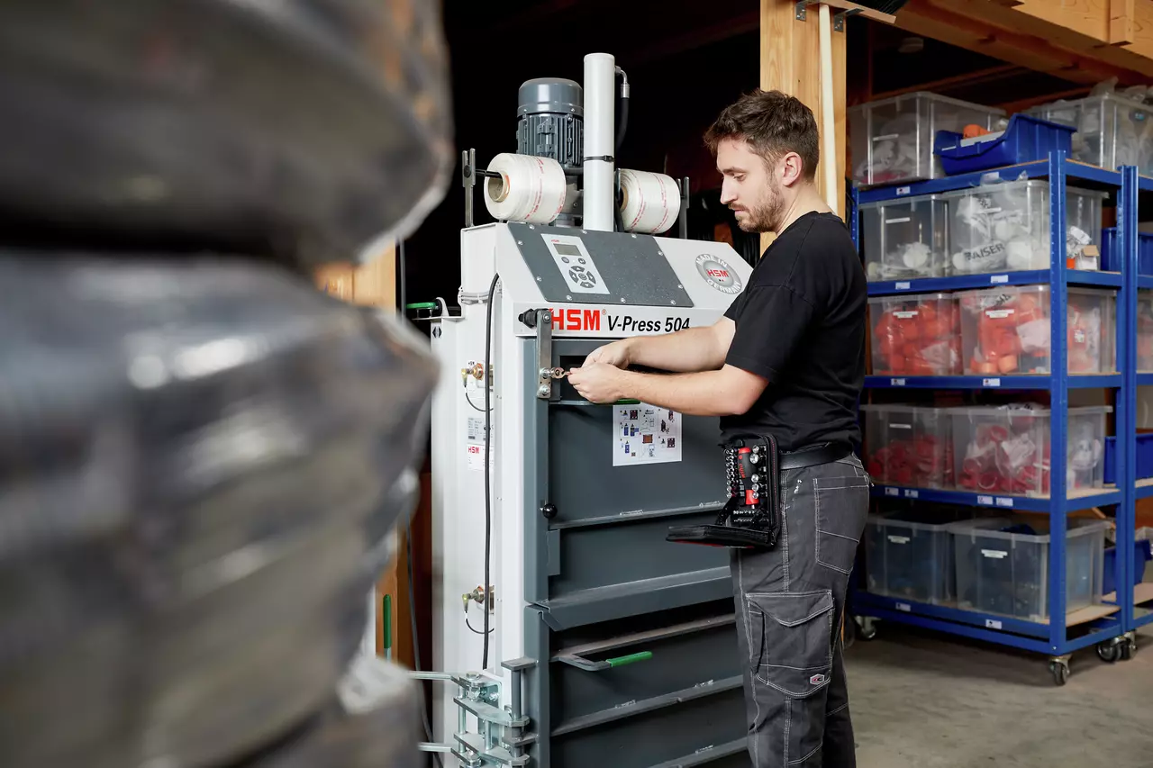 A person operates a large machine in a storage room.