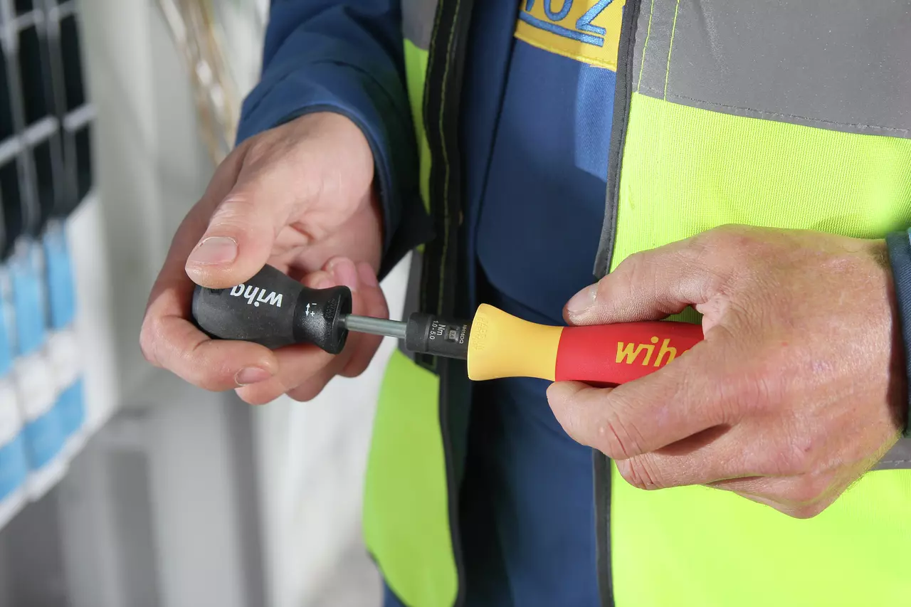 Person holding two screwdrivers with colored handles