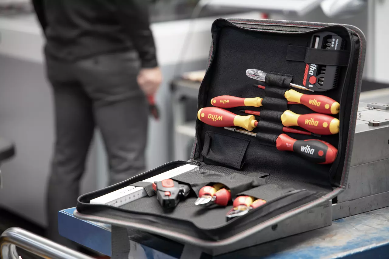 Tool set with screwdrivers in an open case, person in background