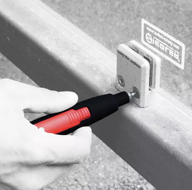 Hand using an electric screwdriver on a cabinet lock