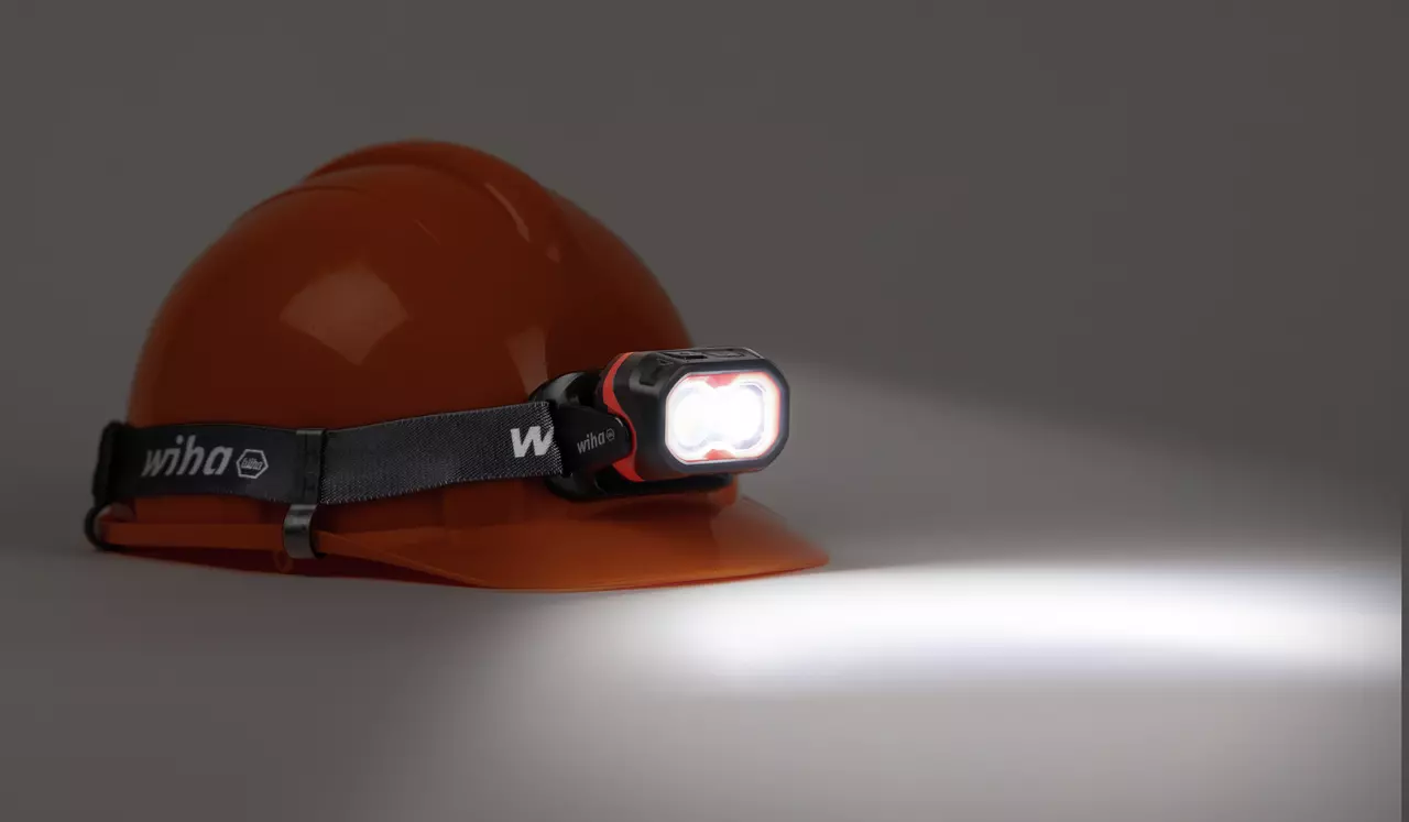 Orange helmet with headlamp shining bright light