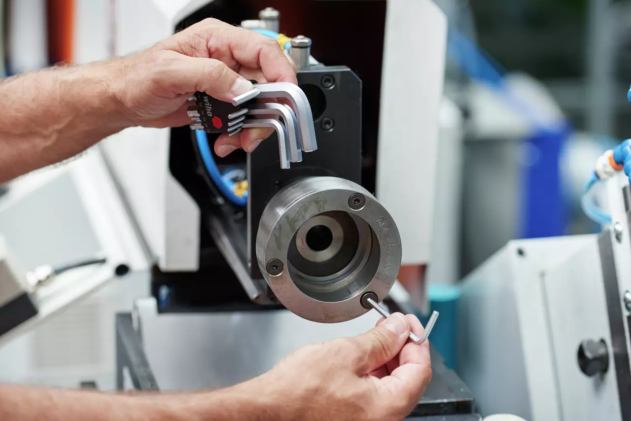 Person using hex key set on a machine.