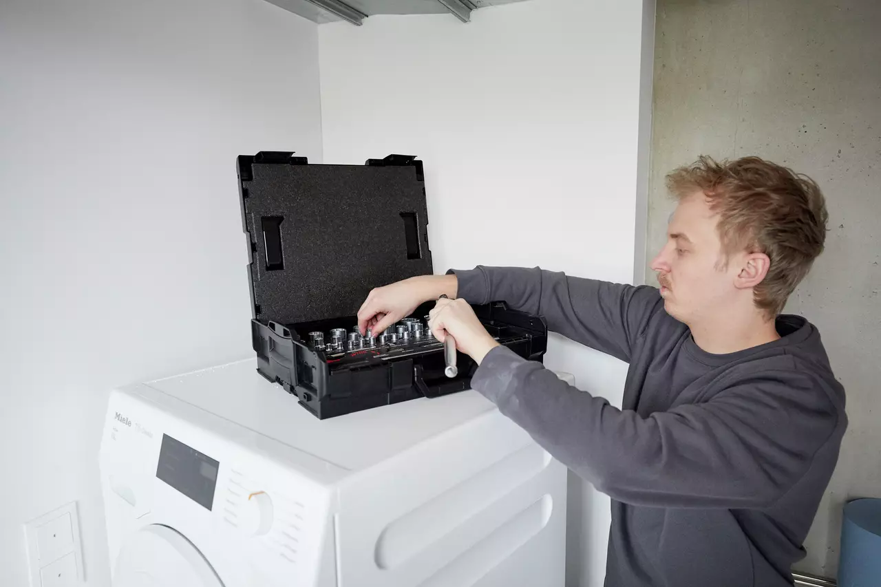 Person working on a socket set on a washing machine
