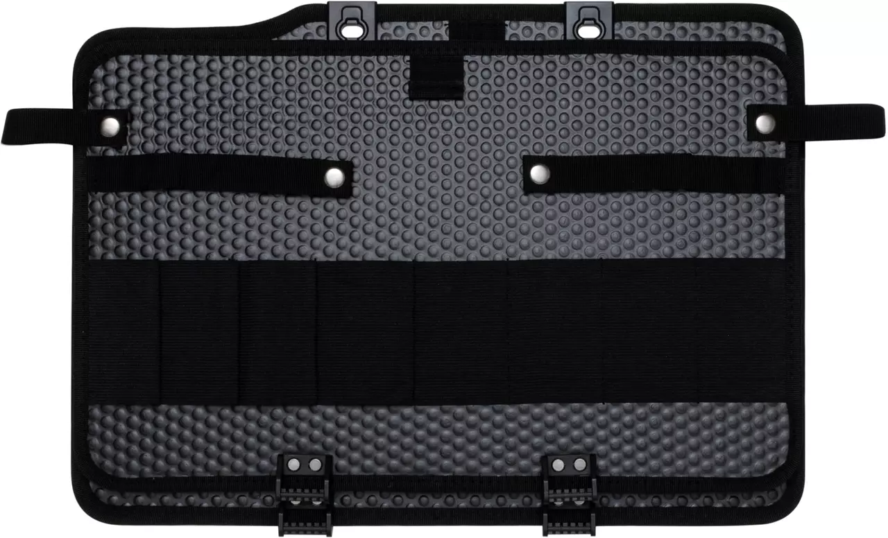 Black and gray tool panel with textured surface and straps for securing tools.