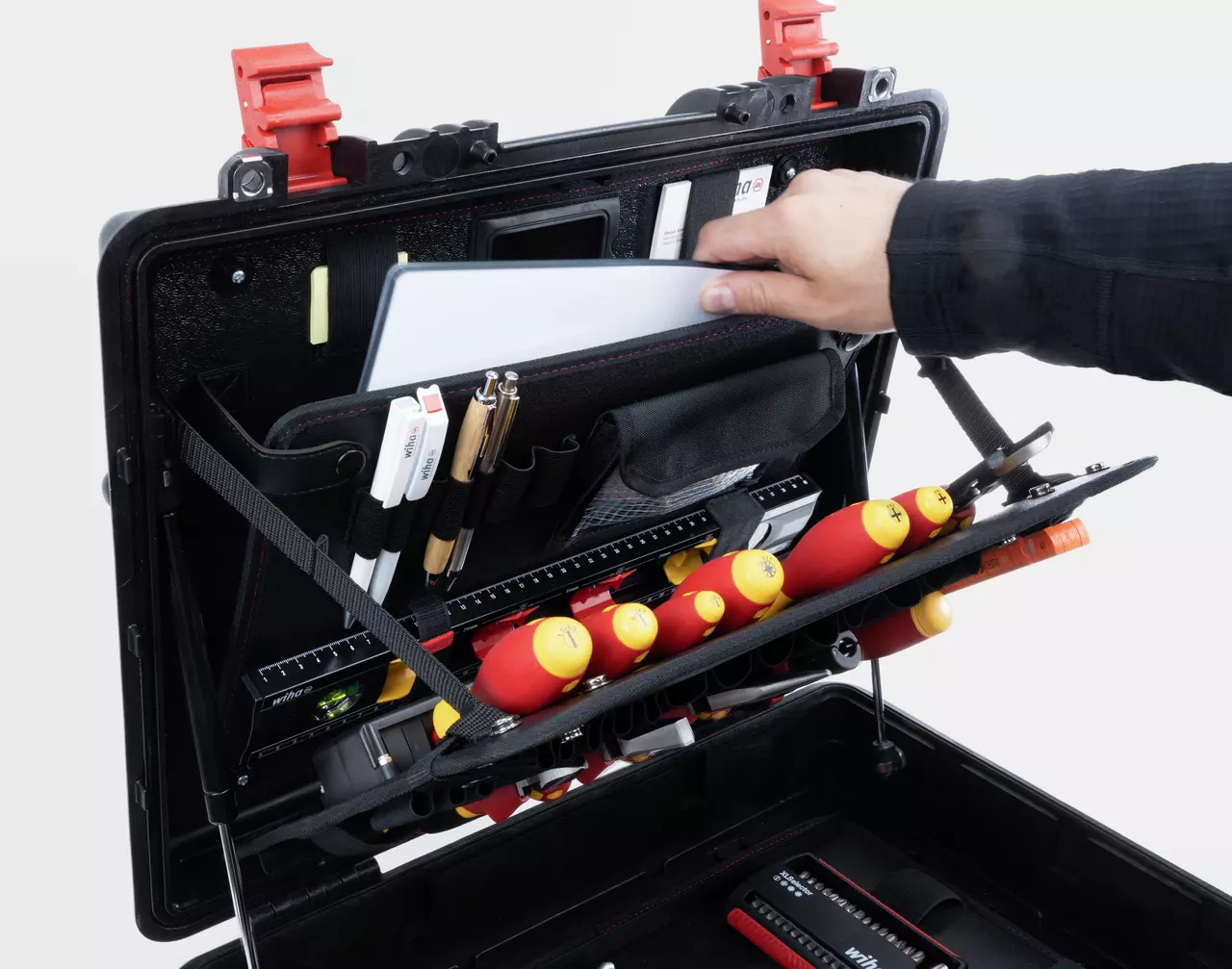Open toolbox with assorted tools and a hand placing a document inside.