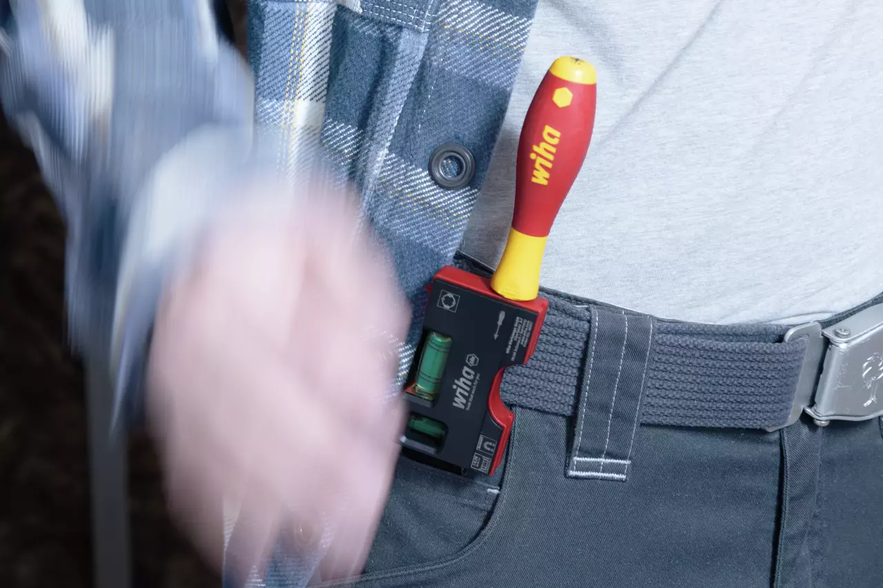 Person with screwdriver and level on belt