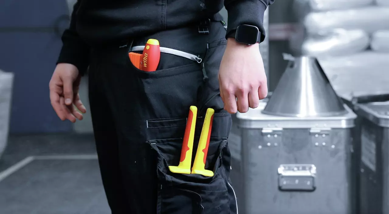 Person with tools in a pocket and wearing a smartwatch