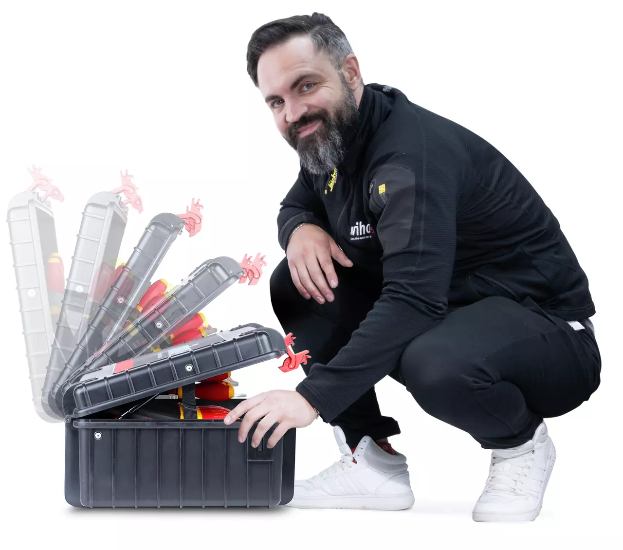 A person crouching next to an open black tool case with visible red tools.