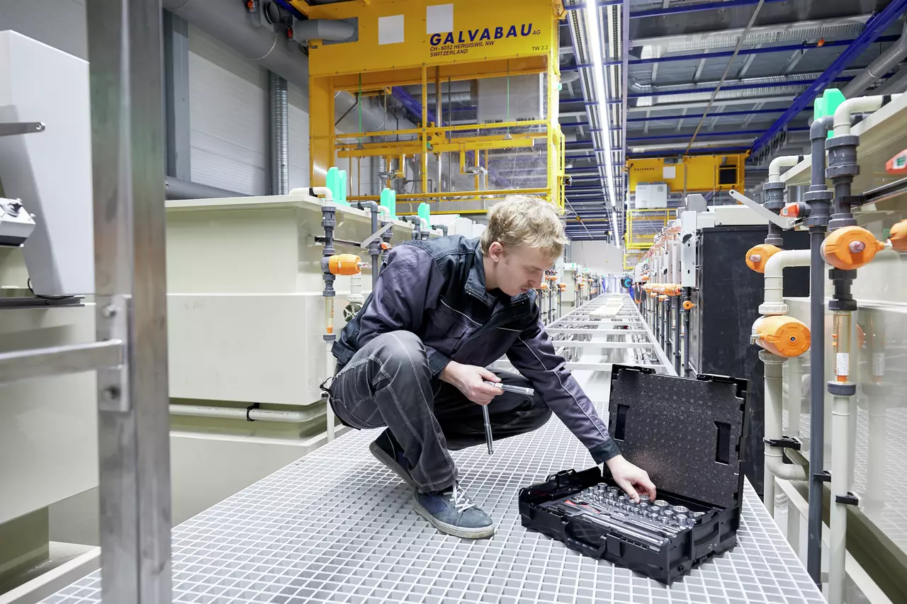 A person working with a socket set in an industrial setting.