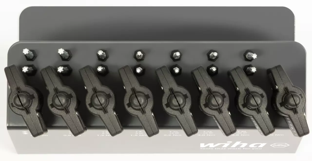 Black torque screwdriver set with multiple settings on a stand.