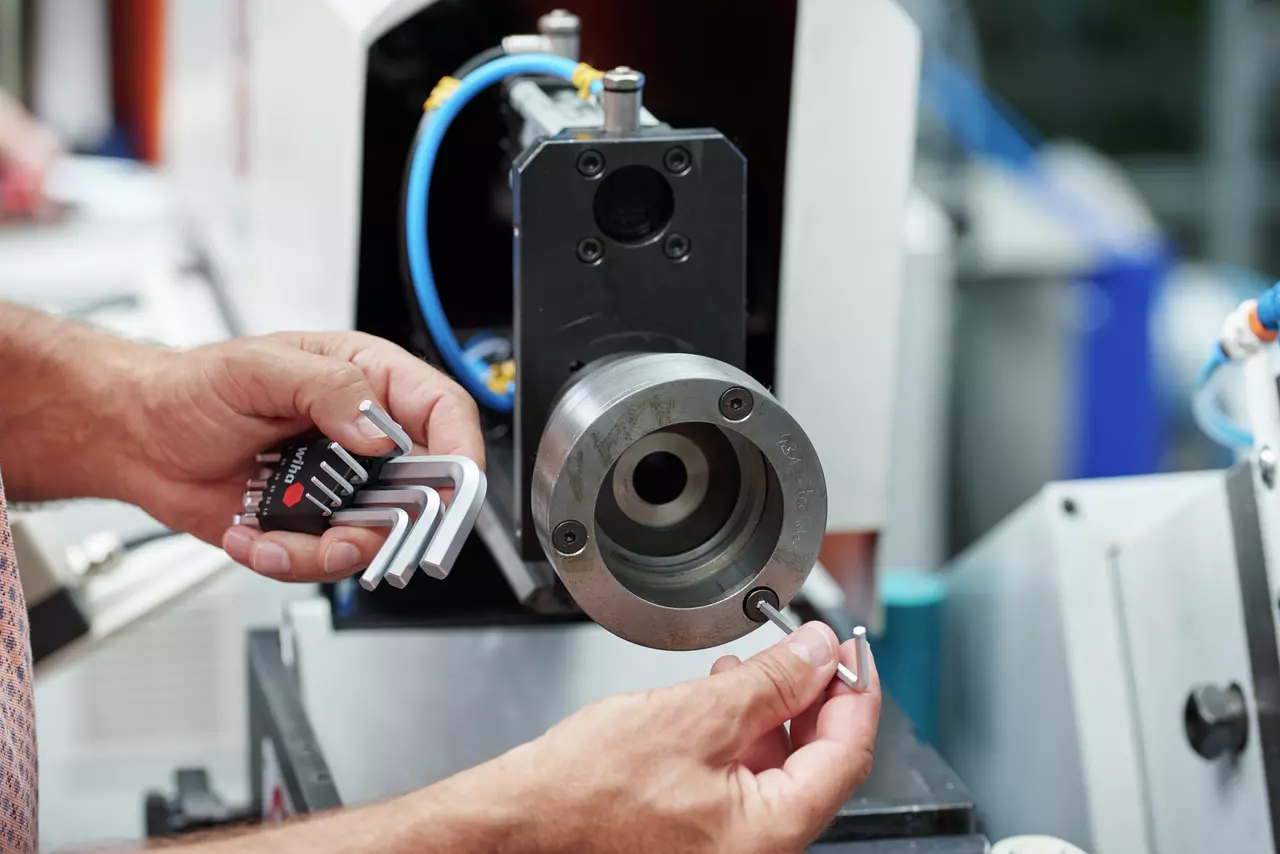 Person using L-shaped hex keys on machinery