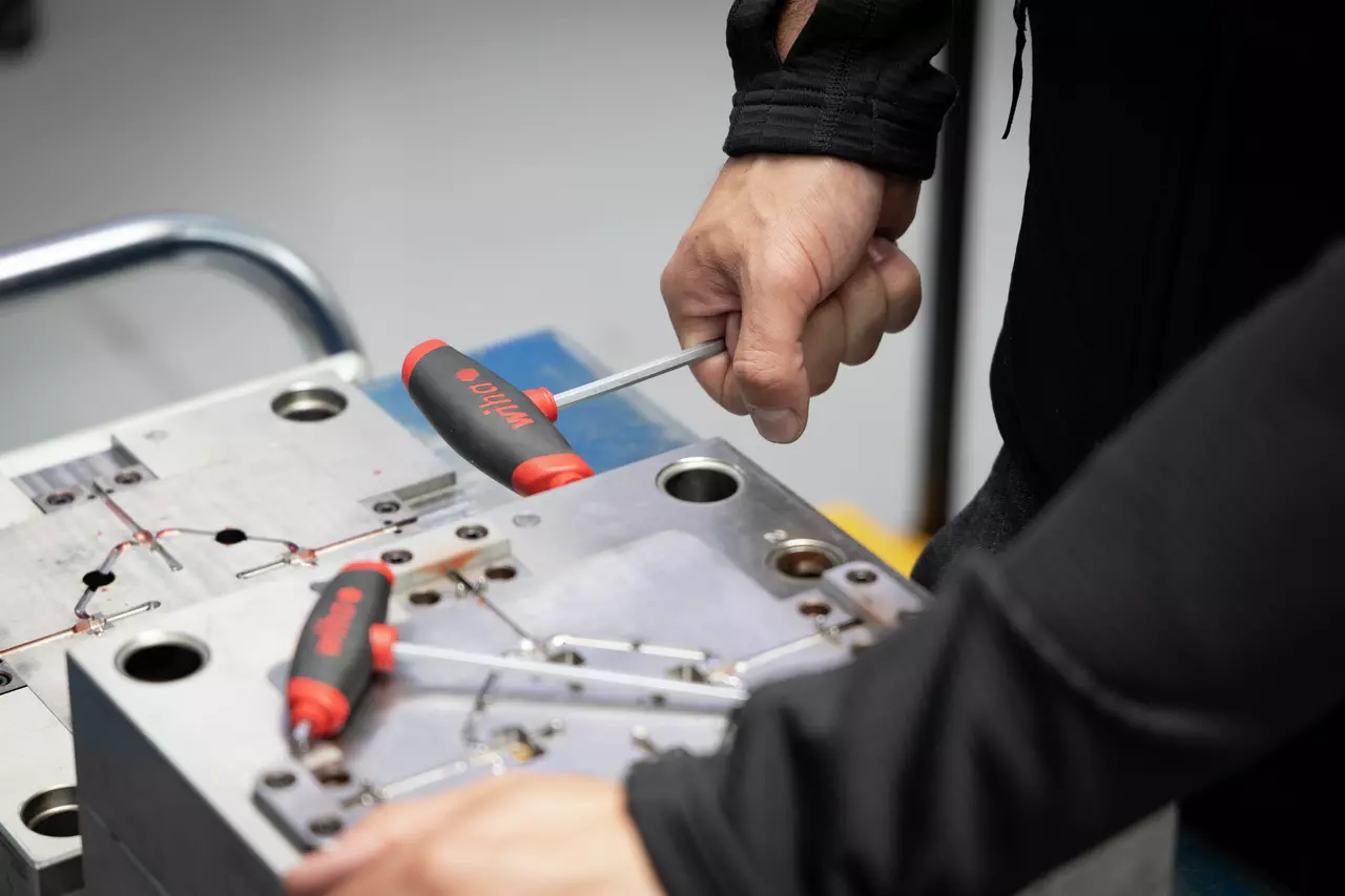 Person using a T-handle wrench on metal equipment