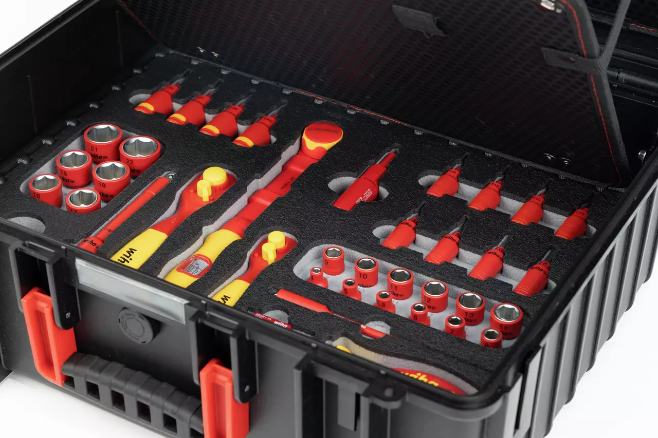 Black tool case with foam insert, filled with red and yellow tools