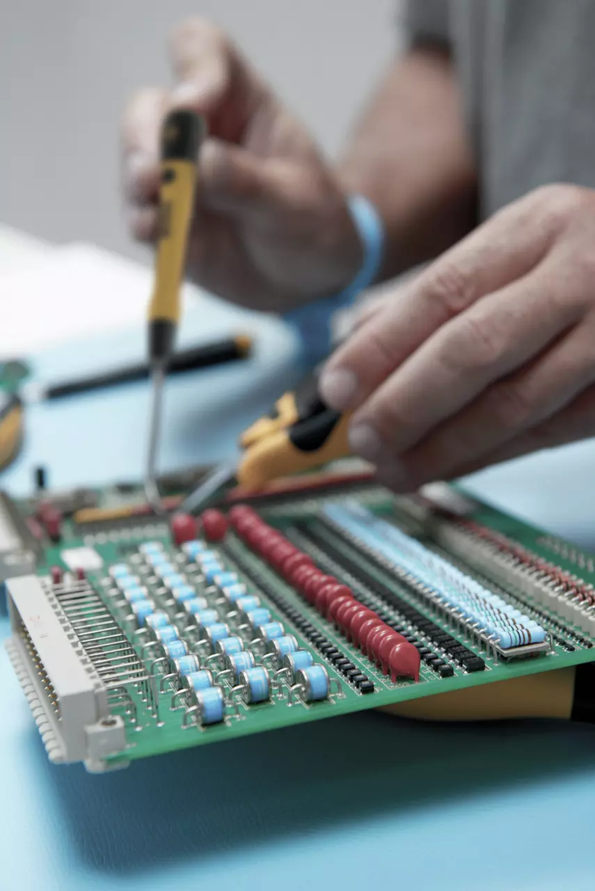 Person using precision screwdriver on circuit board