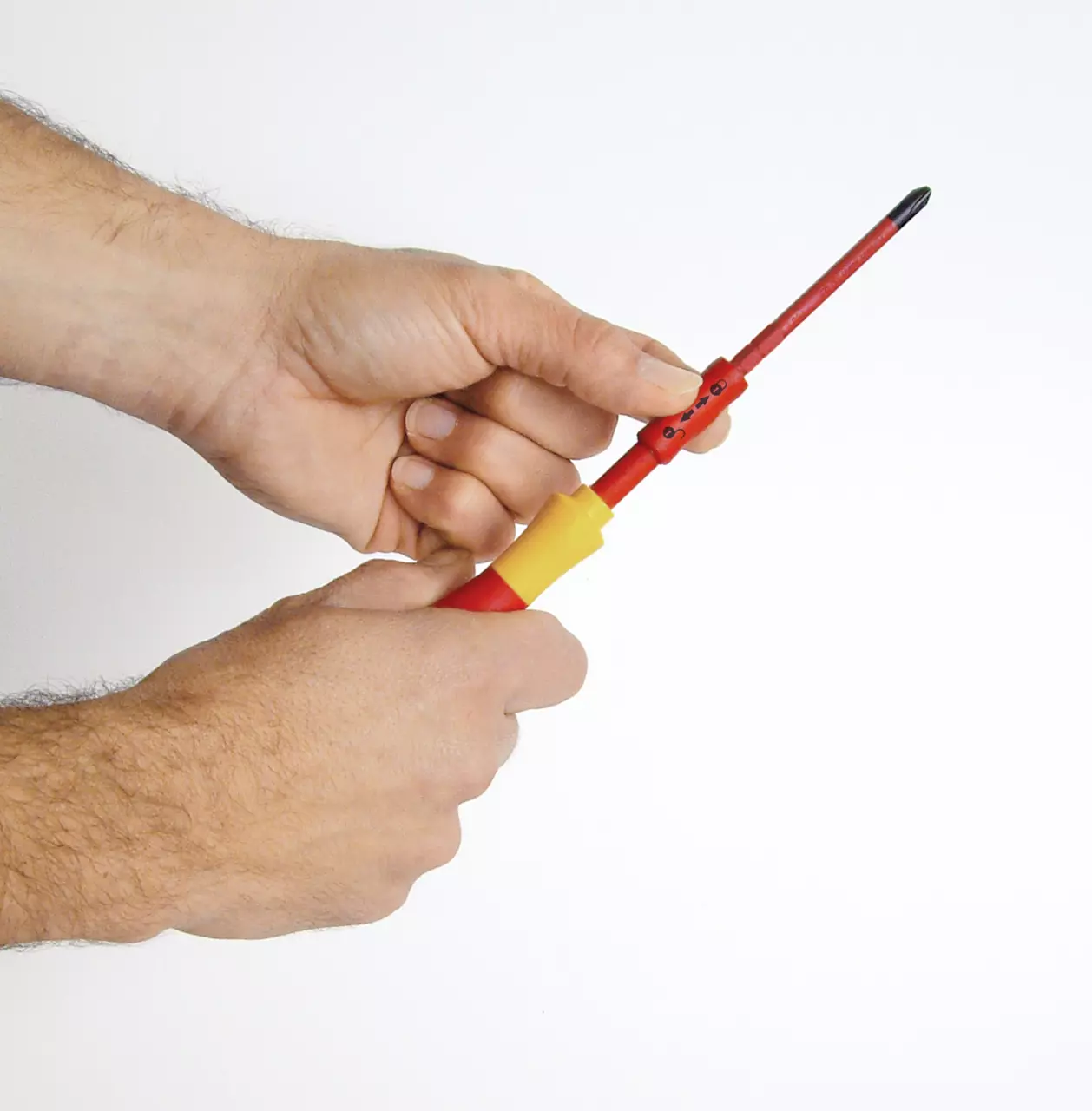 Hands holding a red and yellow screwdriver with a slim bit.