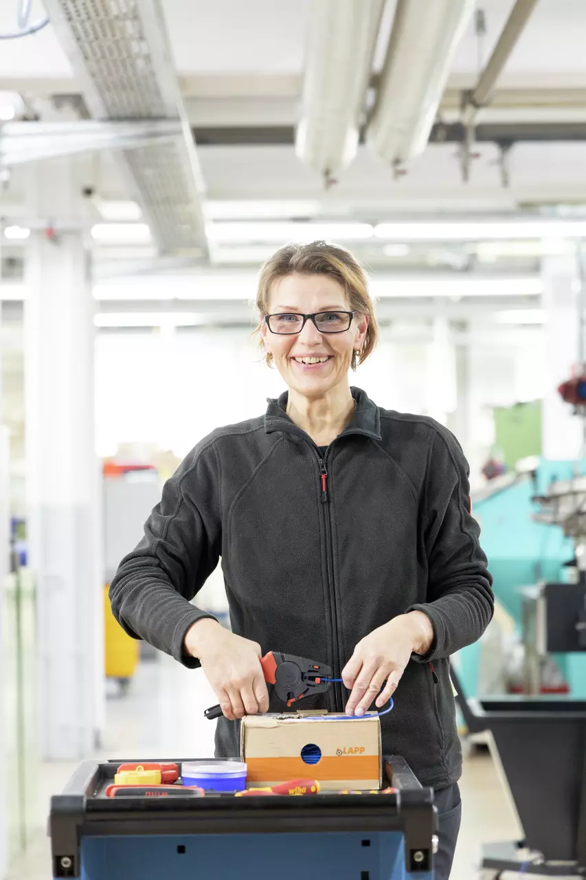 A person using a stripping tool in a workshop.